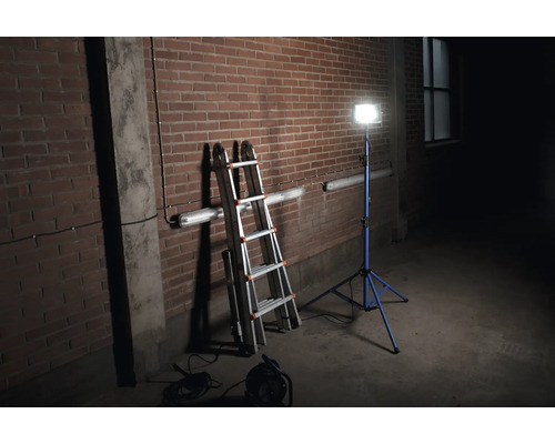 Scen med aluminiumstege och byggstrålkastare mot en tegelvägg