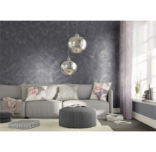 Vardagsrum med grå väggdekoration, soffa, kuddar och hänglampor