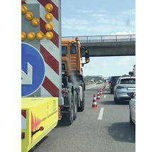 Trafikstockning på motorvägen med varningsledsläp och pyloner
