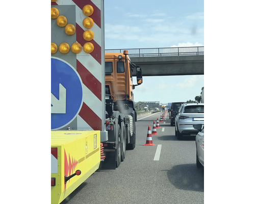 Trafikstockning på motorvägen med varningsledsläp och pyloner