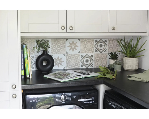 Tvättstuga med tvättmaskin, arbetsbänk, kakel och dekorativa element