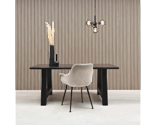 Matsal med matbord, stol och dekoration framför en väggbeklädnad.