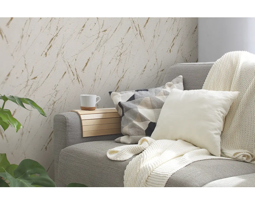 Vardagsrum med grå soffa, kuddar, filt och väggtapet med marmoreffekt