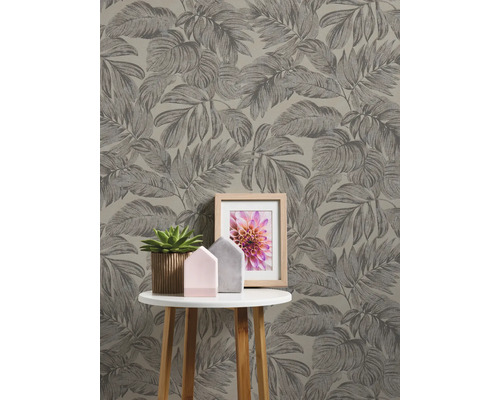 Närbild av en vägg med blad tapet och ett bord med dekoration