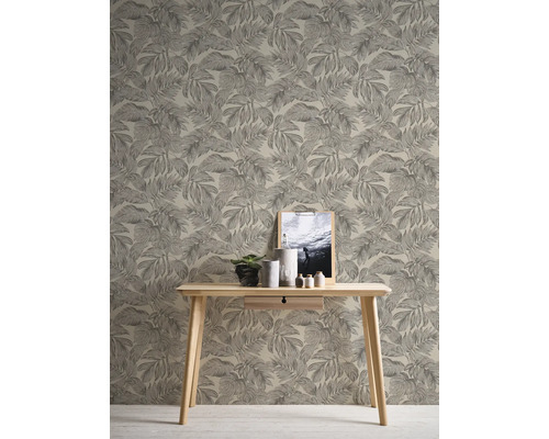 Rumsvy med tapet med bladmönster, träbord, växt, dekoration och inramad bild