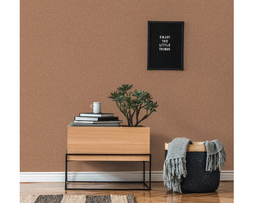 Rumsöversikt med korktapet, sängbord, växt och dekoration