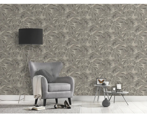 Vardagsrum med fåtölj, golvlampa och tapet med bladmönster