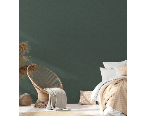 Ljust sovrum med säng, rottingfåtölj och dekoration