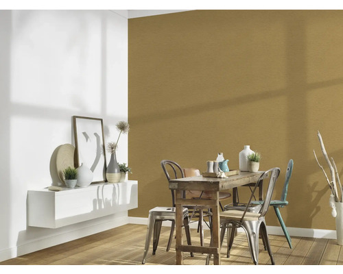 Matsal med träbord, stolar och väggdekoration i guld