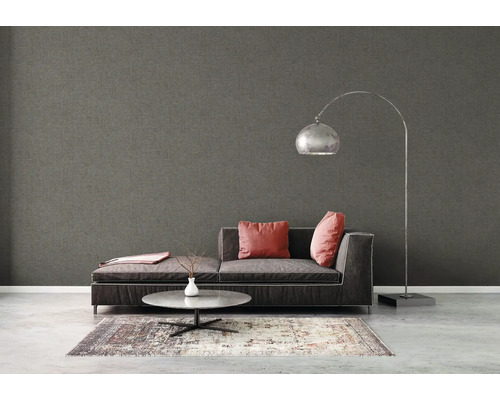 Vardagsrum med grå textiltapet, soffa, lampa och matta