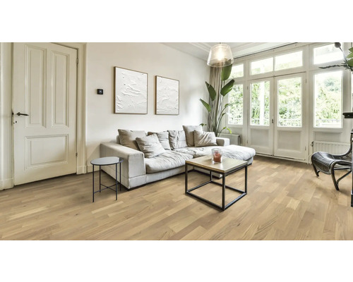 Ljust vardagsrum med trägolv, soffa och fönster