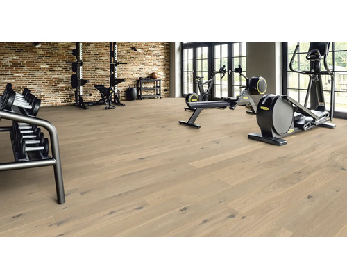 Gym med hantelställ, träningsutrustning och ljust trägolv