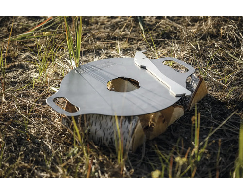 Grillplatta av metall med vedträ utomhus