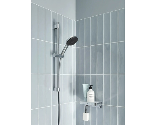 Duschstång med handdusch, hylla och kosmetiska produkter i ett badrum med blått kakel.