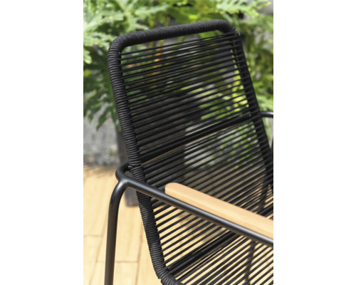 Detaljvy av en svart trädgårdsstol med armstöd