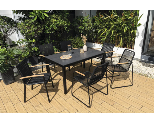 Trädgårdsscen med matbord och stolar för utomhusbruk på en terrass.