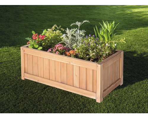 Träplanteringslåda med olika växter i trädgården