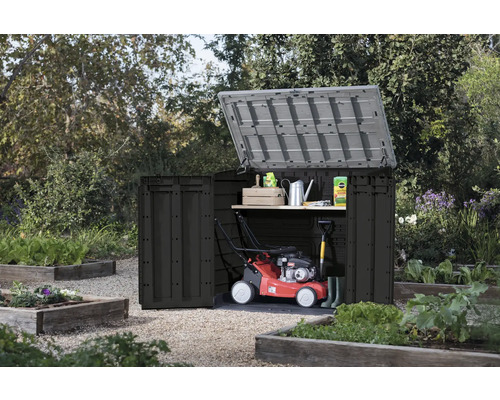 Öppet trädgårdsskåp med trädgårdsredskap i trädgården