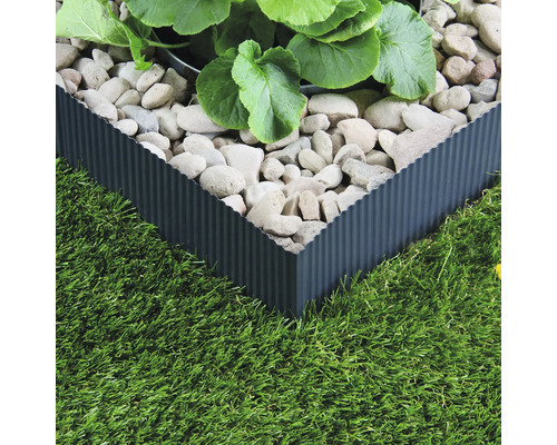 Trädgård med gräsmatta och rabattkant av metall