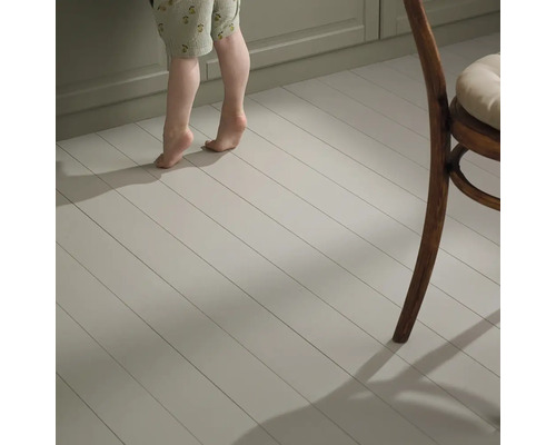 Ljust trägolv med barnfötter och stolsben i rummet