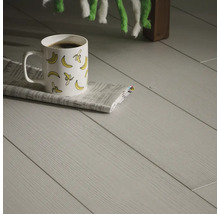 Ljust laminatgolv med en kopp kaffe och en tidning