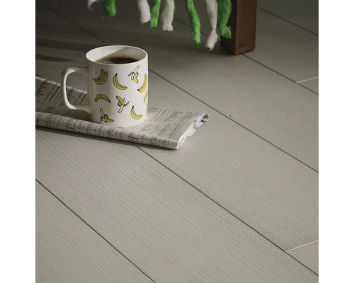 Ljust laminatgolv med en kopp kaffe och en tidning