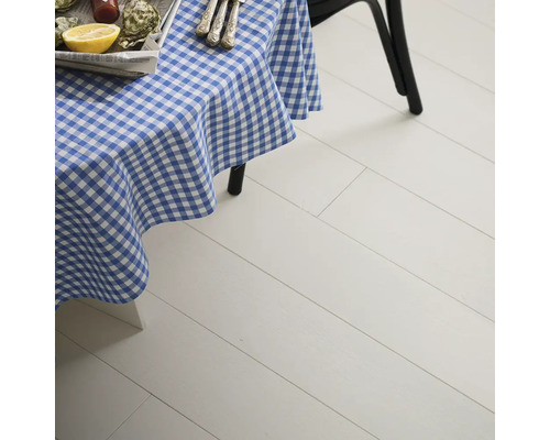 Miljöbild med bord med blå-vitrutig duk och ljust trägolv.