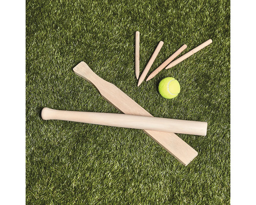 Kubb-spelset i trä med kastpinne, fältpinnar och tennisboll på gräsmatta