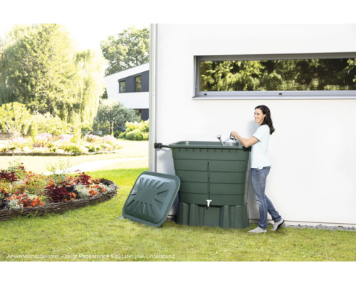 Regntunna med lock och kvinna med vattenkanna i trädgården