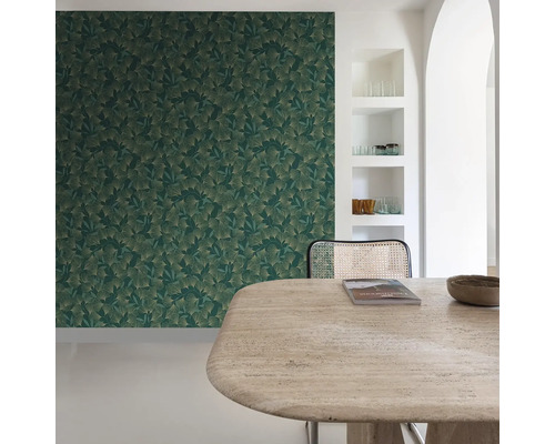 Miljöbild med grön bladtapet, bord och stol