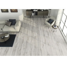 Ljust vardagsrum med trägolv, soffa, fåtölj och skänk