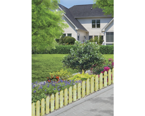 Trädgård med trästaket och blomsterrabatt