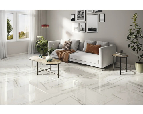 Ljust vardagsrum med marmorplattor, soffa och soffbord.