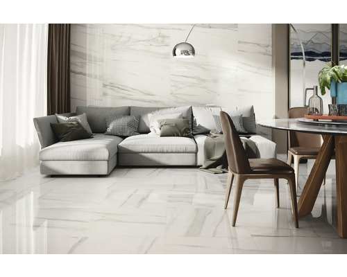 Ljust vardagsrum med kakel i marmorlook, grå hörnsoffa och matbord