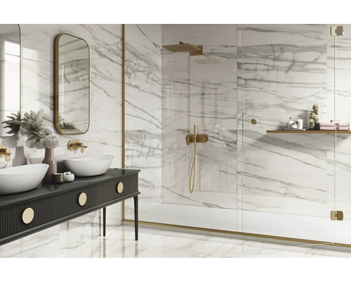 Ljust badrum med marmorplattor, dubbla handfat och dusch med glasvägg