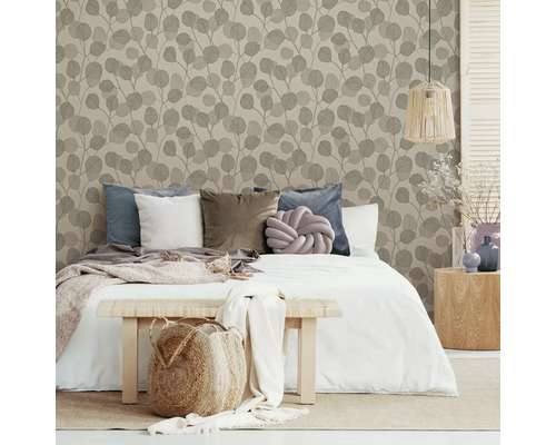 Dekorativt sovrum med säng, kuddar och tapeter med bladmönster