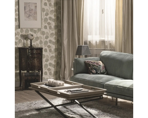 Vardagsrum med soffa, soffbord och blommig tapet