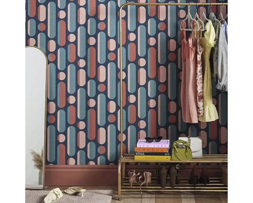 Dekorativt rum med tapeter med geometriska former, klädställning och spegel
