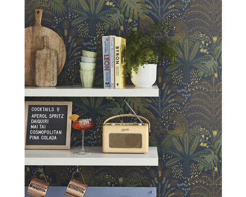 Dekorativ hylla med skärbrädor, porslin, växter, cocktail, radio och cocktailmeny framför en tryckt tapet