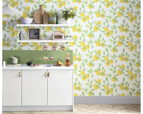 Ljust kök med en vit köksbänk, hyllor och en tapet med citronmönster för en fräsch atmosfär