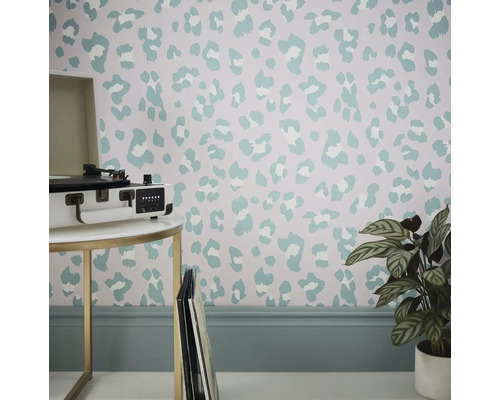 Rum med tapet i djurmönsterdesign, bord med skivspelare och krukväxt