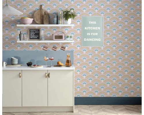 Ljust kök med mönstrad tapet, vita hyllor och köksredskap