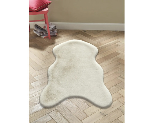 Ljusfärgad fårskinnsmatta på trägolv