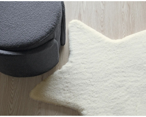 Dekorativt arrangemang med en grå pall och en vit stjärnformad matta