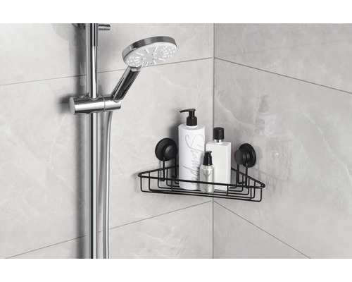 Hörnhylla med sugproppar i ett badrum med duschhuvud och vårdprodukter.