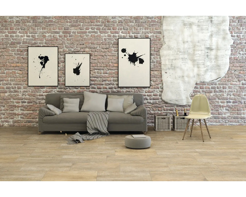 Vardagsrum med soffa, stol och väggdekoration framför en tegelvägg