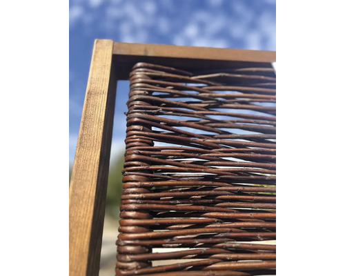 Närbild av ett pilstängselelement med träram