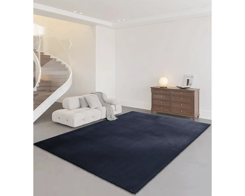 Vardagsrum med trappa, soffa, byrå och rektangulär matta