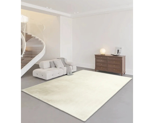 Ljust vardagsrum med soffa, byrå och rektangulär matta