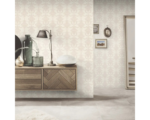 Dekorativt rum med blommönstrad tapet, byrå och spegel